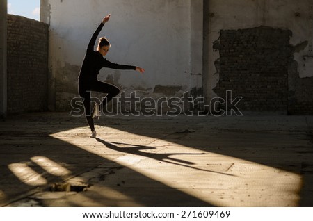 Young modern dancer exercising and dancing in abandoned building.