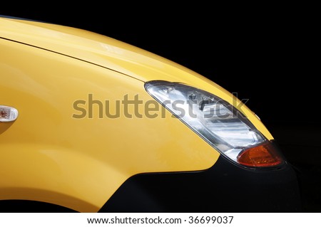 Front of the yellow sports car with accent on the big silver front light.
