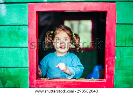 Little girl playing in wooden house  in nature