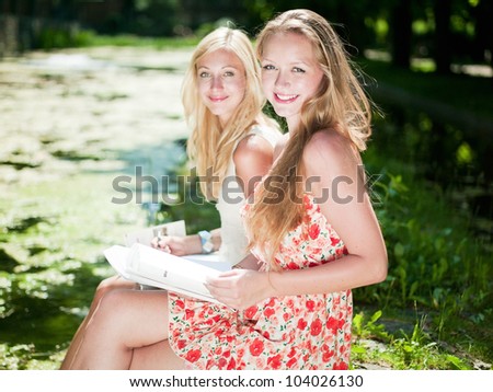 two girls are learning outside in the park