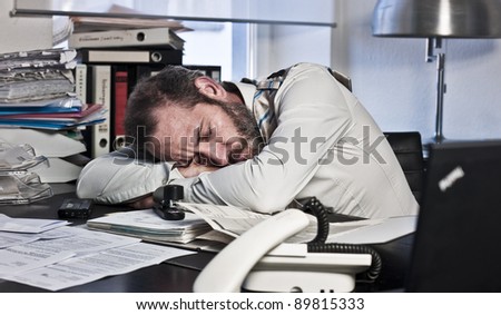 Overworked Businessman sleeps on his workdesk