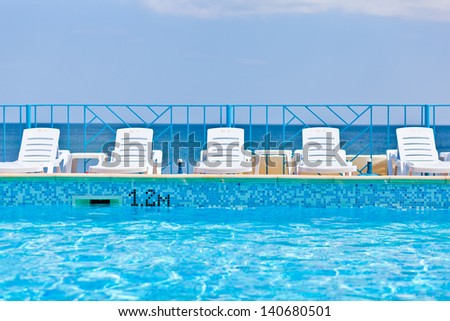 white lounge chairs on sea background