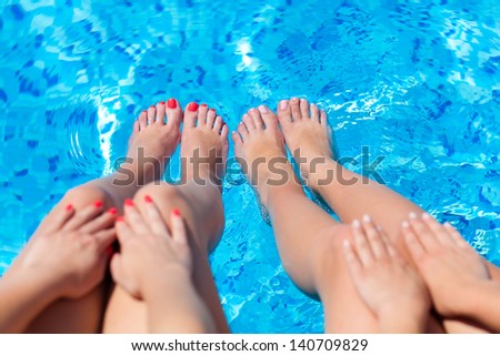 feet on a background of water in swimming pool