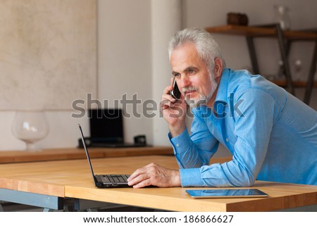 old man with notebook  and talking on the phone