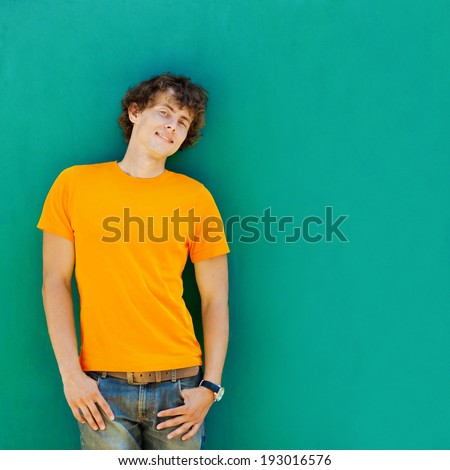 man with curly hair in a yellow T-shirt