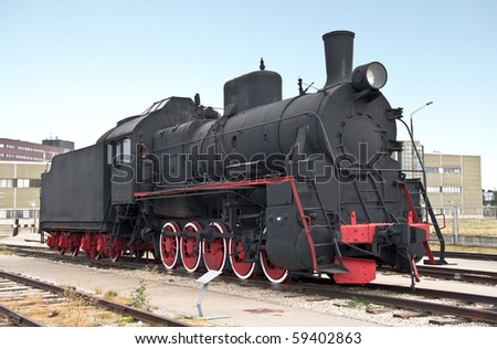 Steam locomotive beside a railway station platform. Retro train.