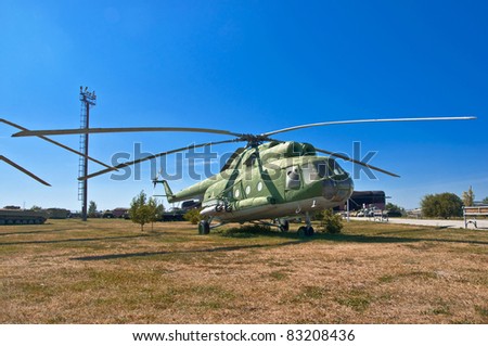 old Russian helicopter on the grass. Against the background of blue sky.