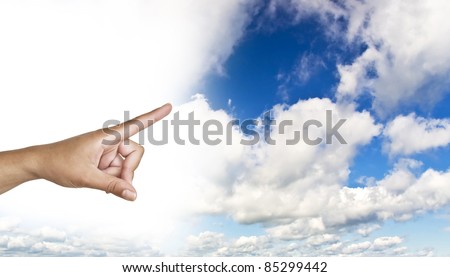 hand on the blue clear sky. Woman\'s hand with index finger.