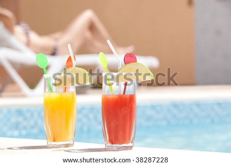 Drinks by the pool with young women sunbathing in the back