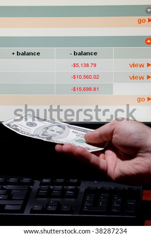 Hand holding Dollars to the fake web page displaying debt on credit card