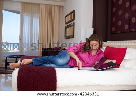Young woman in hotel room reading card