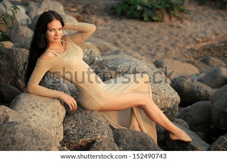 Woman in dress sitting on stones