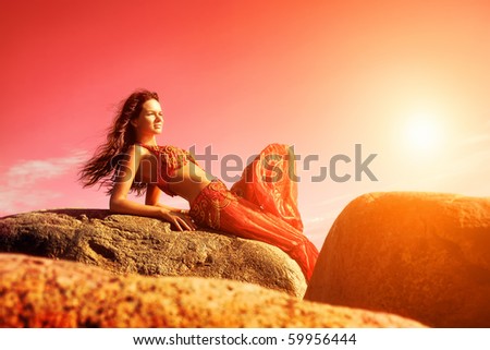 Woman in indian dress sitting on stones