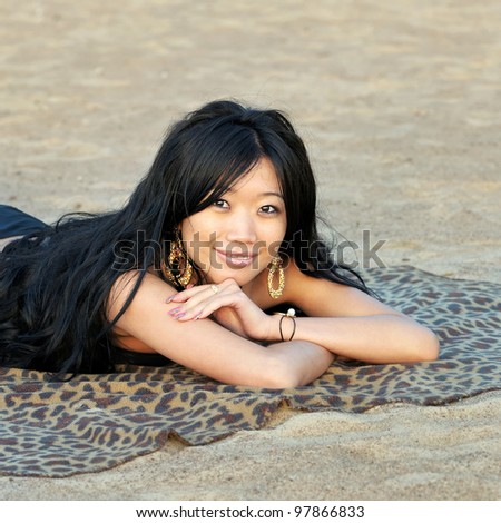 Asian woman resting on the sand