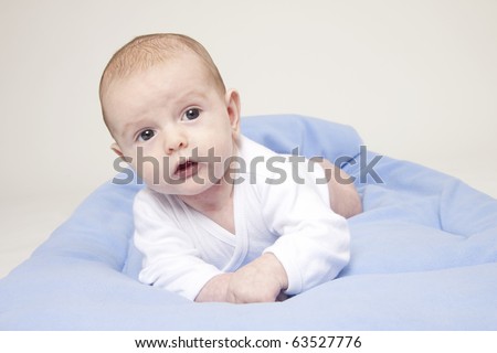 Portrait of cute baby boy with blue blanket and shoes