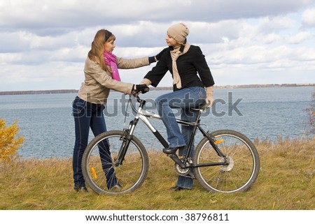 Two girls and a bicycle. Autumn, day, cloudy.