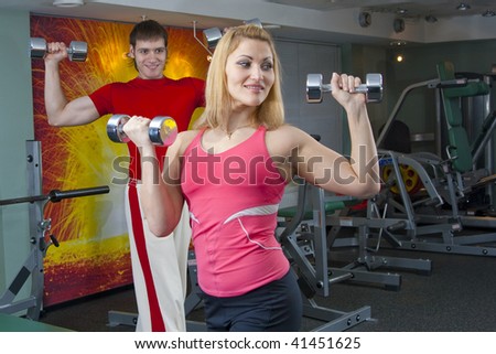 The woman and the man at realization of gymnastics to free weights