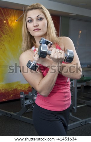 woman at the gym exercising with free weights