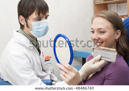 Choice of color of a dental artificial limb. The woman on reception at the dentist.