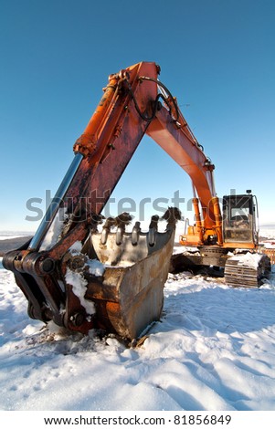 Photo with an orange excavator in snow