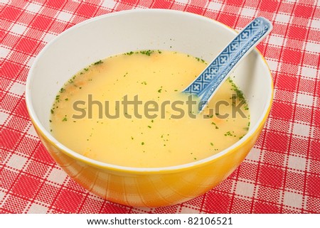 Bowl of vegetables cream soup in red and white table cloth