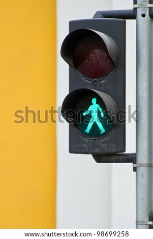 Pedestrian traffic light with the green light lit.
