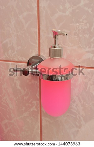 Soap dispenser attached to the wall in bathroom