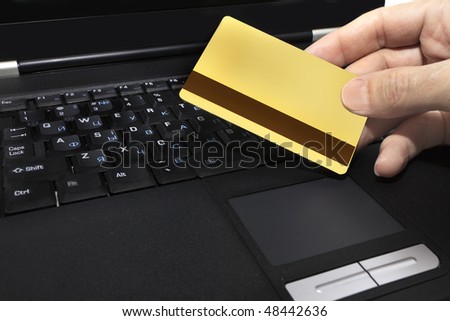 gold credit card on the background of a laptop