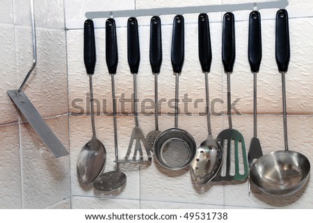 rack of kitchen utensils, stainless steel with black handles