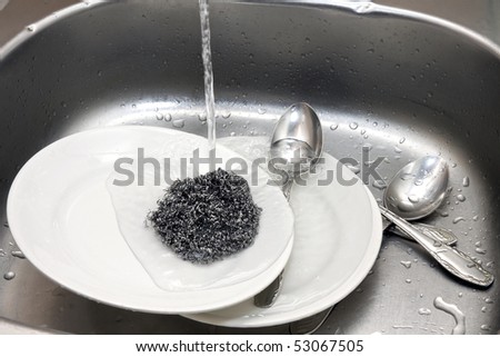 dishes in the kitchen sink under running water