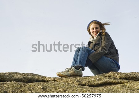 Woman Sat On Top Of A Rock