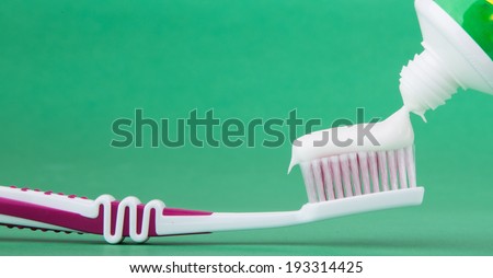 toothbrush with toothpaste isolated on a green background