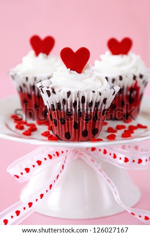 Red velvet cupcakes with cream cheese frosting decorated with red chocolate hearts