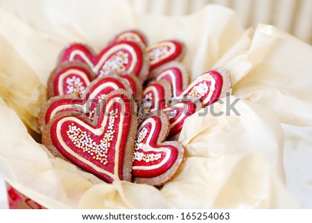 Heart shaped gingerbread cookies decorated in red and gold for Christmas