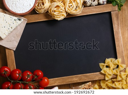 Italian food on vintage wood background, with chalkboard, with copyspace