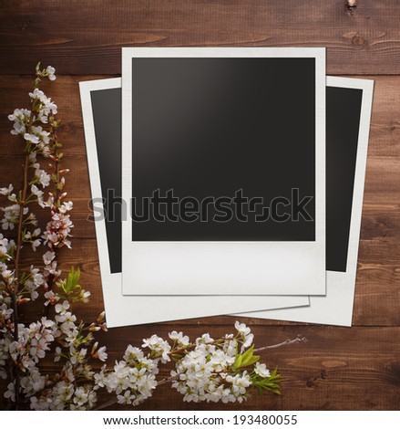 Blank photo frame with summer flowers on wood background for design or montage