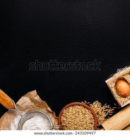 Ingredients for baking including eggs and flour, with sieve and whisk flour on empty light wooden background with place for your text or recipes.