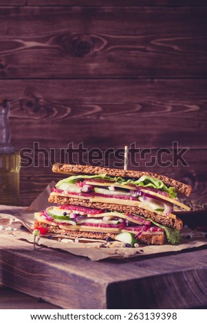 One piece of sandwich on old papper with big cutting board. In vitage style. With space for text.