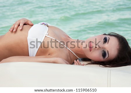 The beautiful girl lies on a boat and has a rest