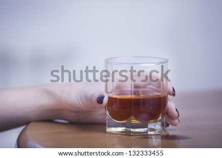 glass of scotch whiskey in hand