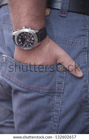man holding hand with wrist watches in pocket