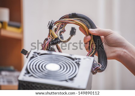 hands hold the power supply from PC
