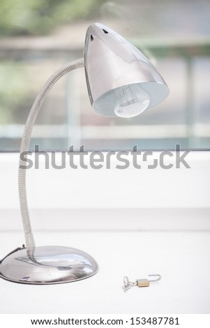 Modern reading-lamp stands on a window ledge