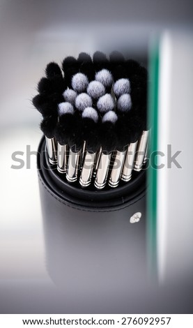 makeup brush set in a glass beaker isolated on background