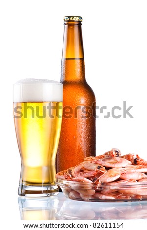 Brown bottle of beer with a condensate, glass and plate of boiled shrimp on Isolated white background