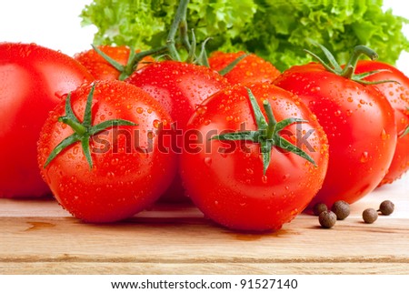 Fresh wet tomatoes, allspice and lettuce on a cutting board wooden Isolated on white background