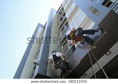 Facade Cleaning. Glass Cleaning Services.  Workers washing the windows facade of a modern office building.