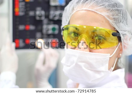 Pharmaceutical Factory Worker. Worker Using Control Panel.\
A female technician is monitoring the process of pill packaging.
