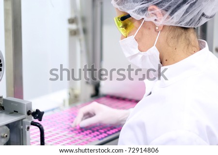 Pill Manufacturing. Pharmaceutical Industry. Medicine Production. \
Technician inspecting the quality of pills at a pharmaceutical plant.