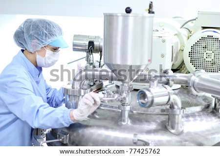 Preparing machine for work in pharmaceutical factory. Chemical industry.\
Pharmaceutical Factory Worker. Pharmaceutical Industry.